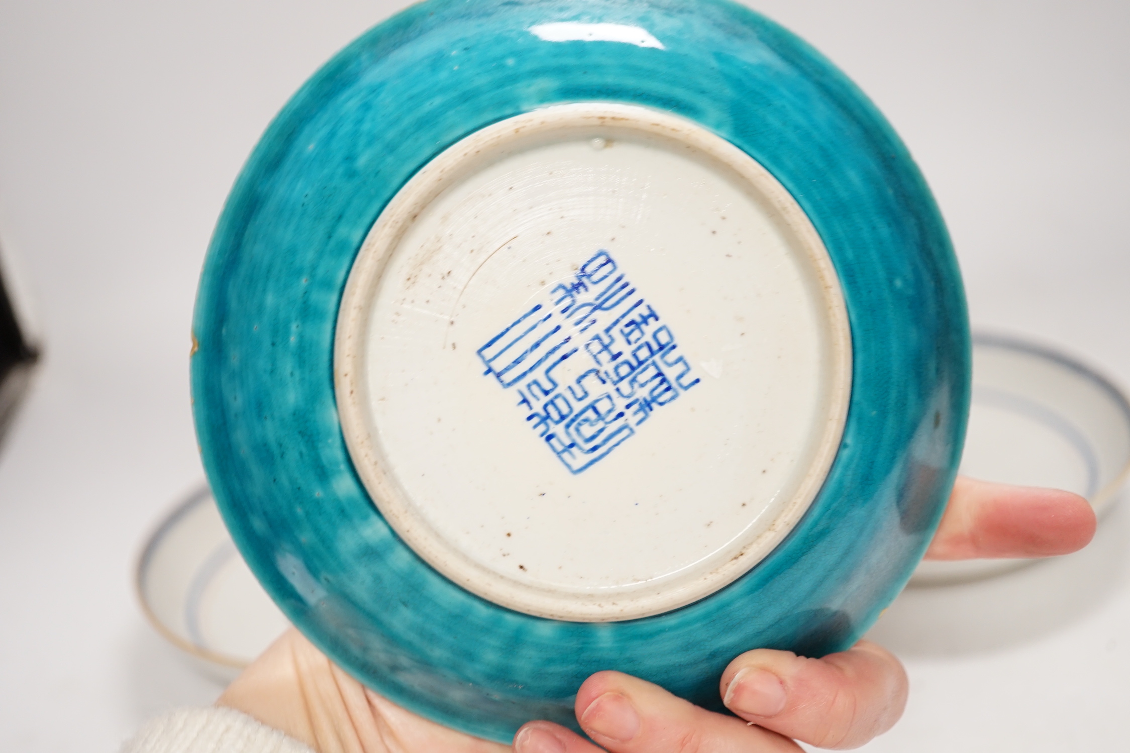 A Chinese turquoise glazed saucer dish, Qianlong Mark and period and two Chinese export famille rose saucers, Qianlong period, 16cm diameter